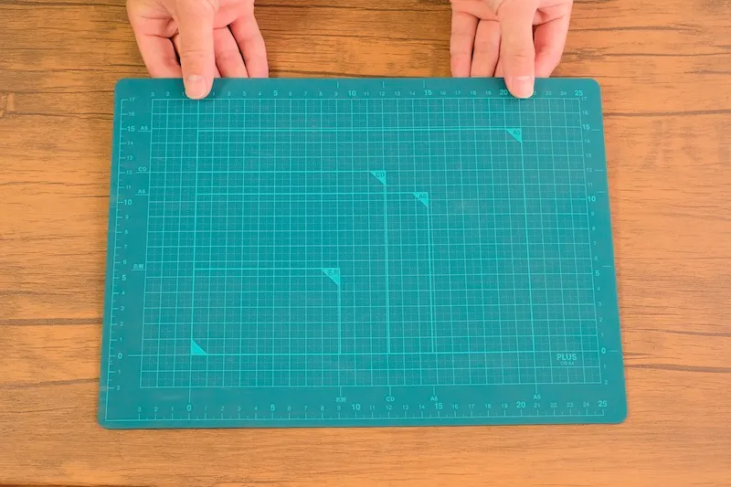 Hands preparing a green cutting mat