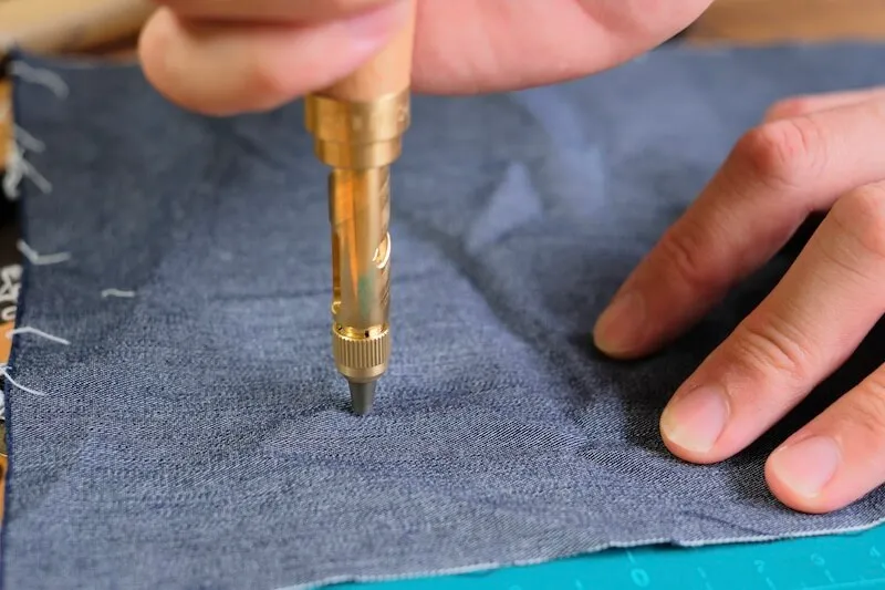 Holding a Nonaka Screw Punch vertically over fabric